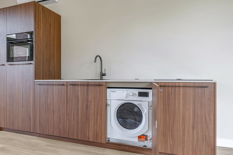 Keuken van appartement 188B met houten fronten en ingebouwde wasmachine