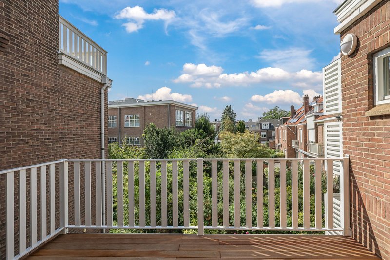 Balkon van appartement 188B met houten vlonder en witte balustrade