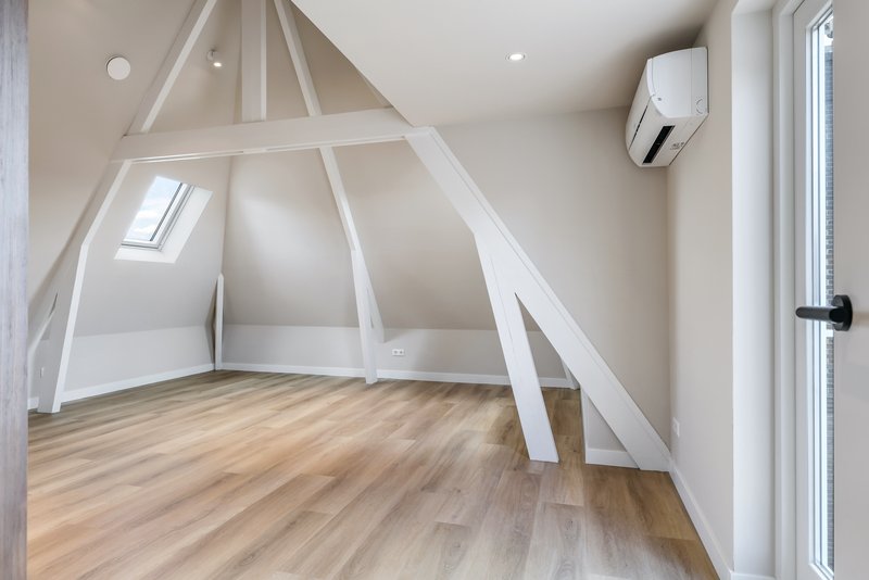 Lichte woonkamer van appartement 188C met dakraam en hoge witte balken