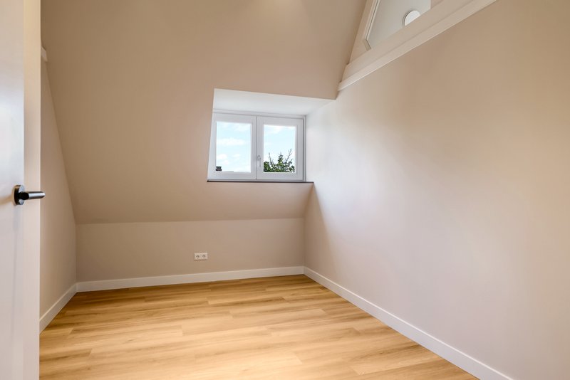 Slaapkamer van appartement 188C met raam en glazen bovenwand