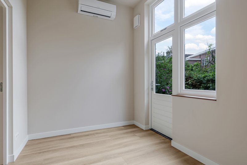 Slaapkamer van appartement 188A met raam en airconditioning
