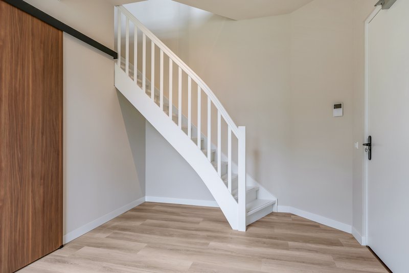 Interne trap en houten schuifdeur naar de badkamer van appartement 188