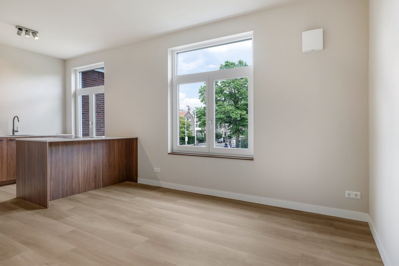 Lichte woonkamer met grote ramen en keuken van appartement 188